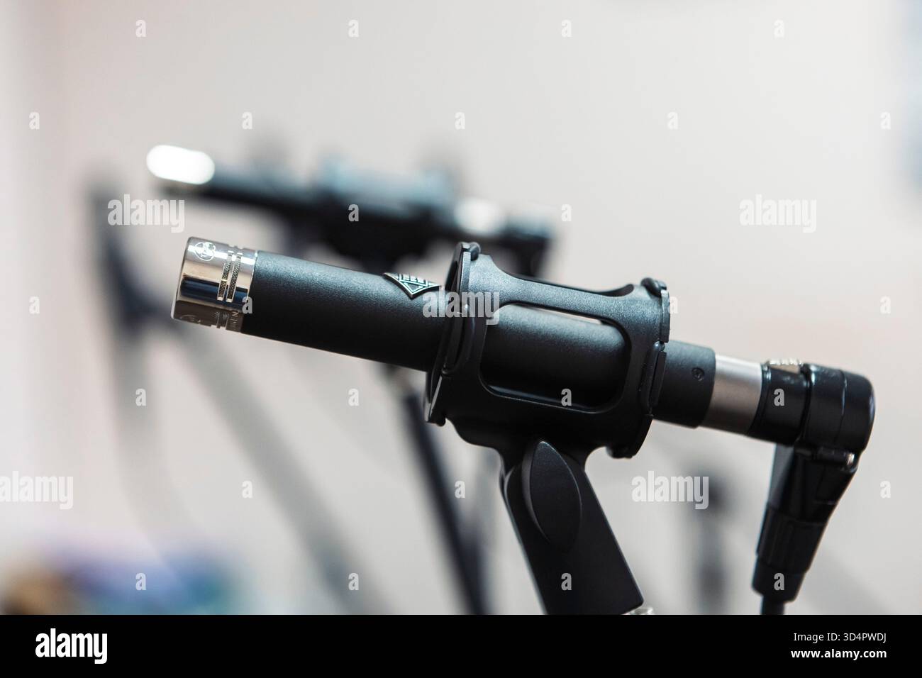 Primo piano di microfoni in uno studio, cattura l'audio con precisione, circondato da cavi e apparecchiature sotto controllo per registrare musica Foto Stock