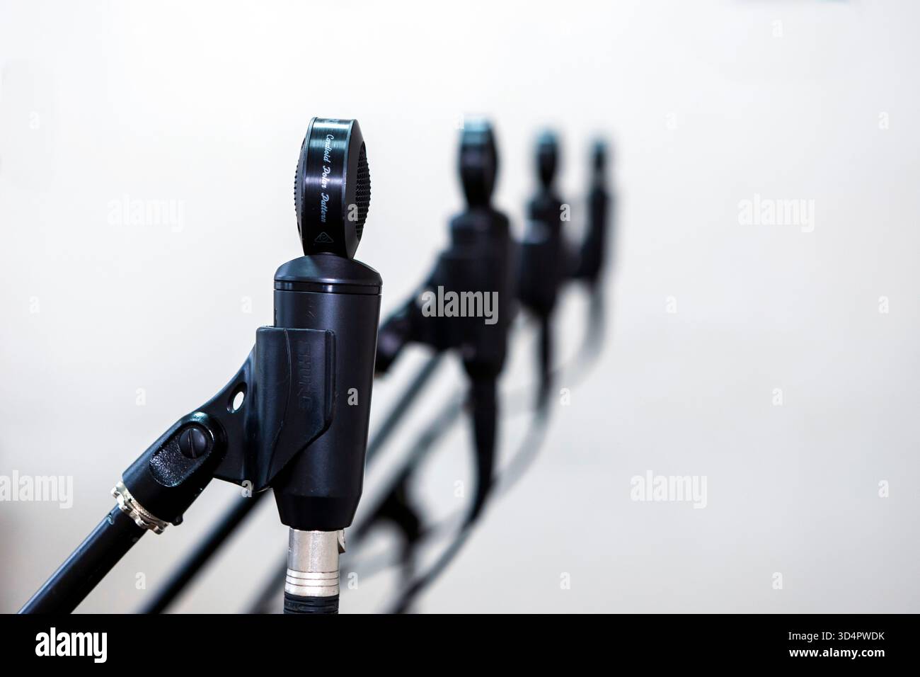 Primo piano di microfoni in uno studio, cattura l'audio con precisione, circondato da cavi e apparecchiature sotto controllo per registrare musica Foto Stock