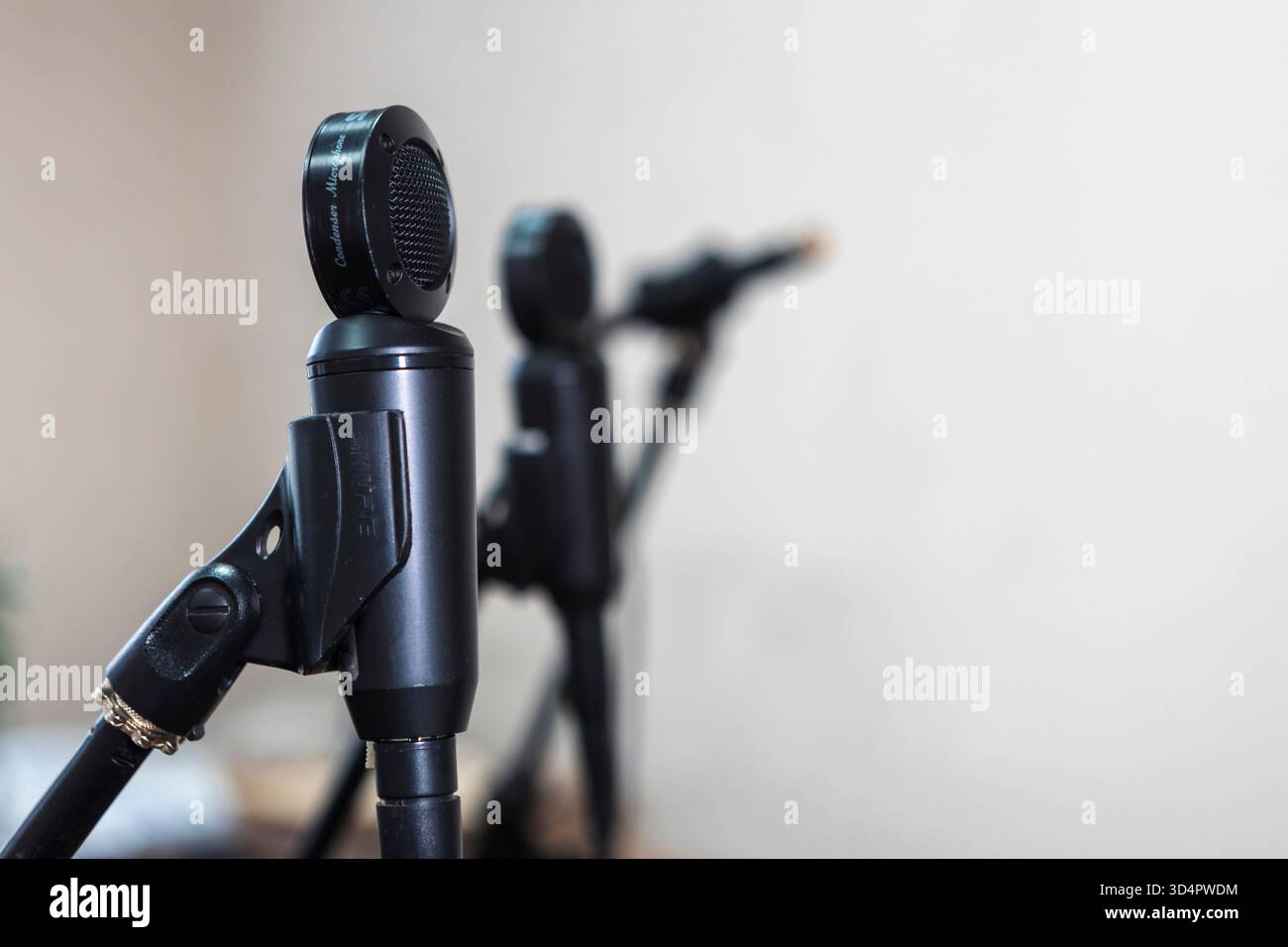 Primo piano di microfoni in uno studio, cattura l'audio con precisione, circondato da cavi e apparecchiature sotto controllo per registrare musica Foto Stock