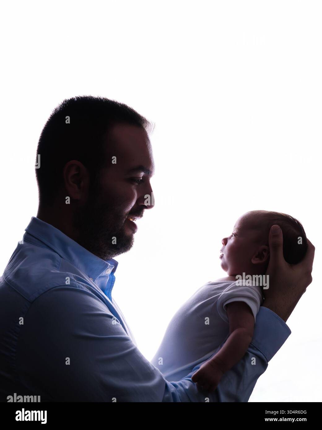 Padre che tiene in braccio il neonato irradiando amore e cura Foto Stock