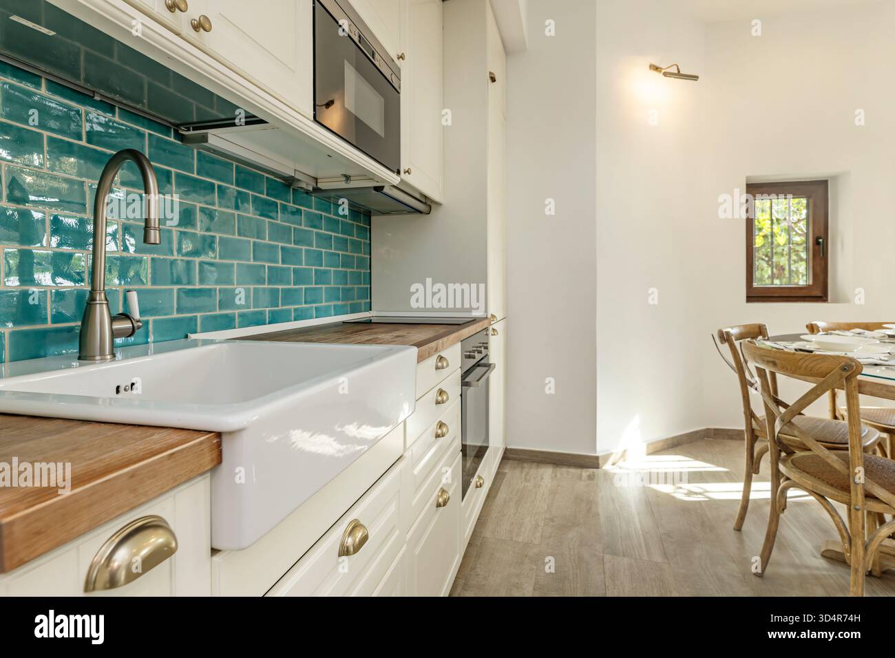 Fotografia di una piccola cucina con pareti blu e armadi di base grigio scuro, che creano un contrasto visivo contemporaneo. Foto Stock