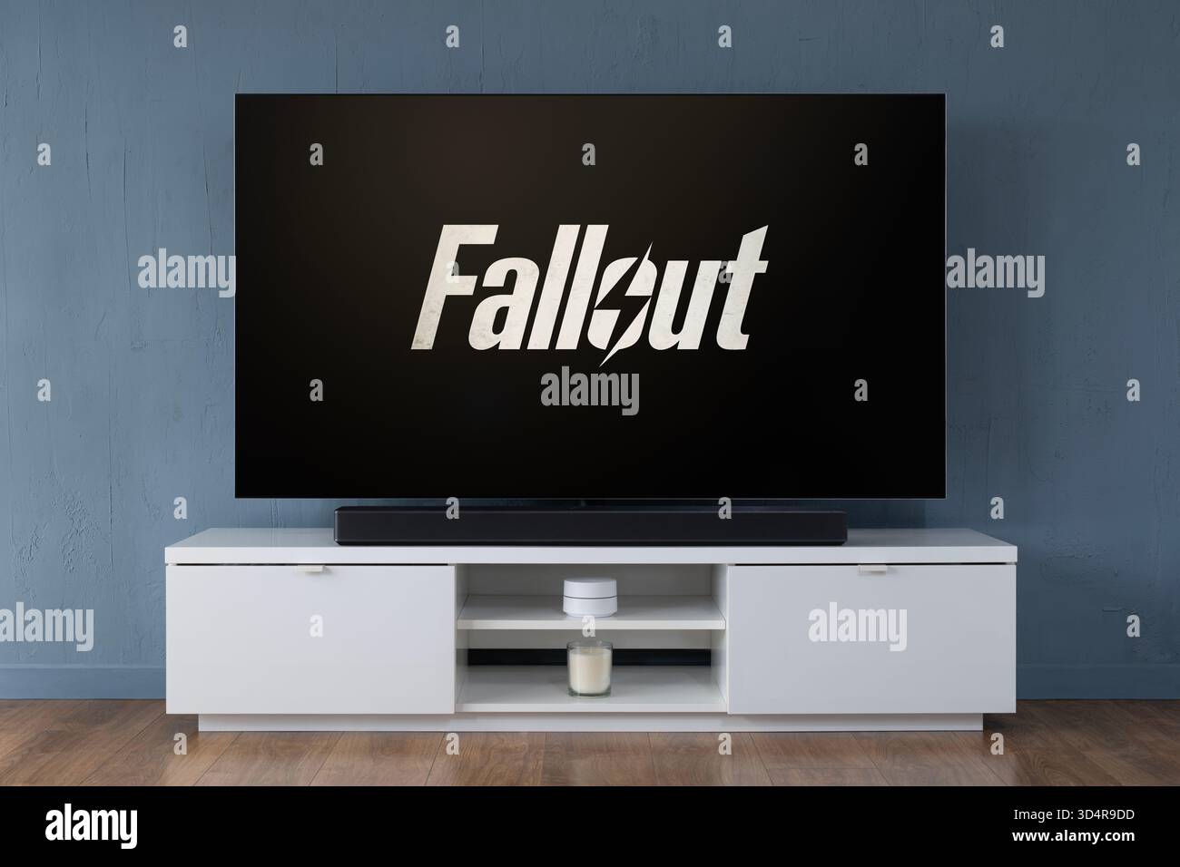 Un televisore OLED widescreen che mostra la scena introduttiva della serie TV Fallout, visto in un salotto contemporaneo. Foto Stock