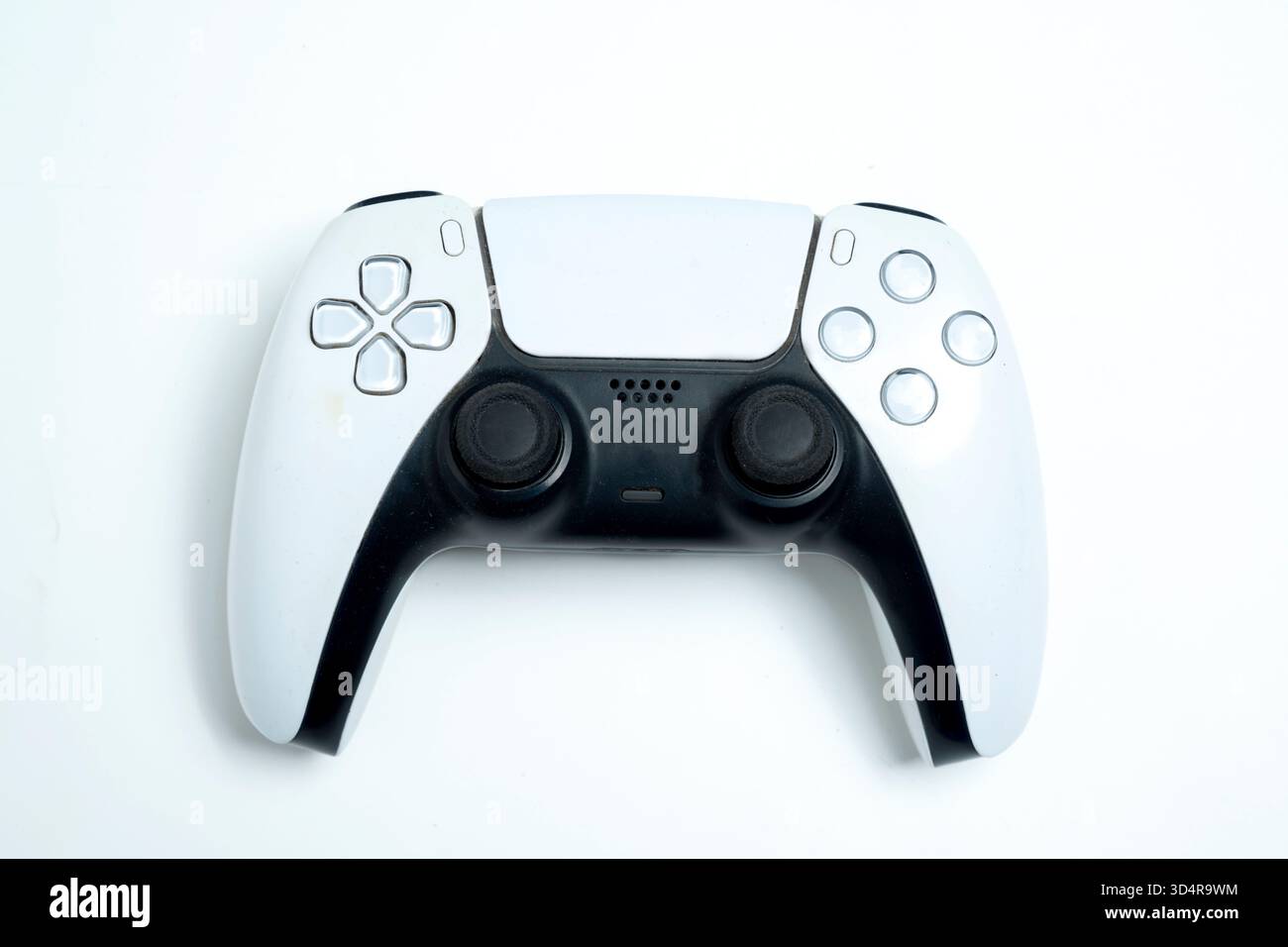 Moderno controller di gioco wireless bianco e nero per console su sfondo bianco. Giocare a giochi interattivi su una console Foto Stock