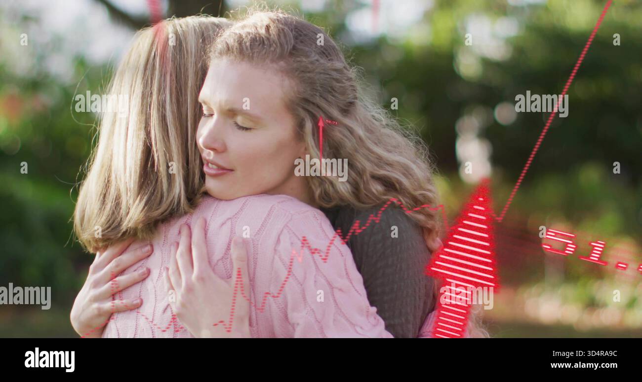 Abbracciare due donne che condividono il comfort in giardino, indossando maglioni in maglia scura e rosa con sovrapposizioni rosse Foto Stock