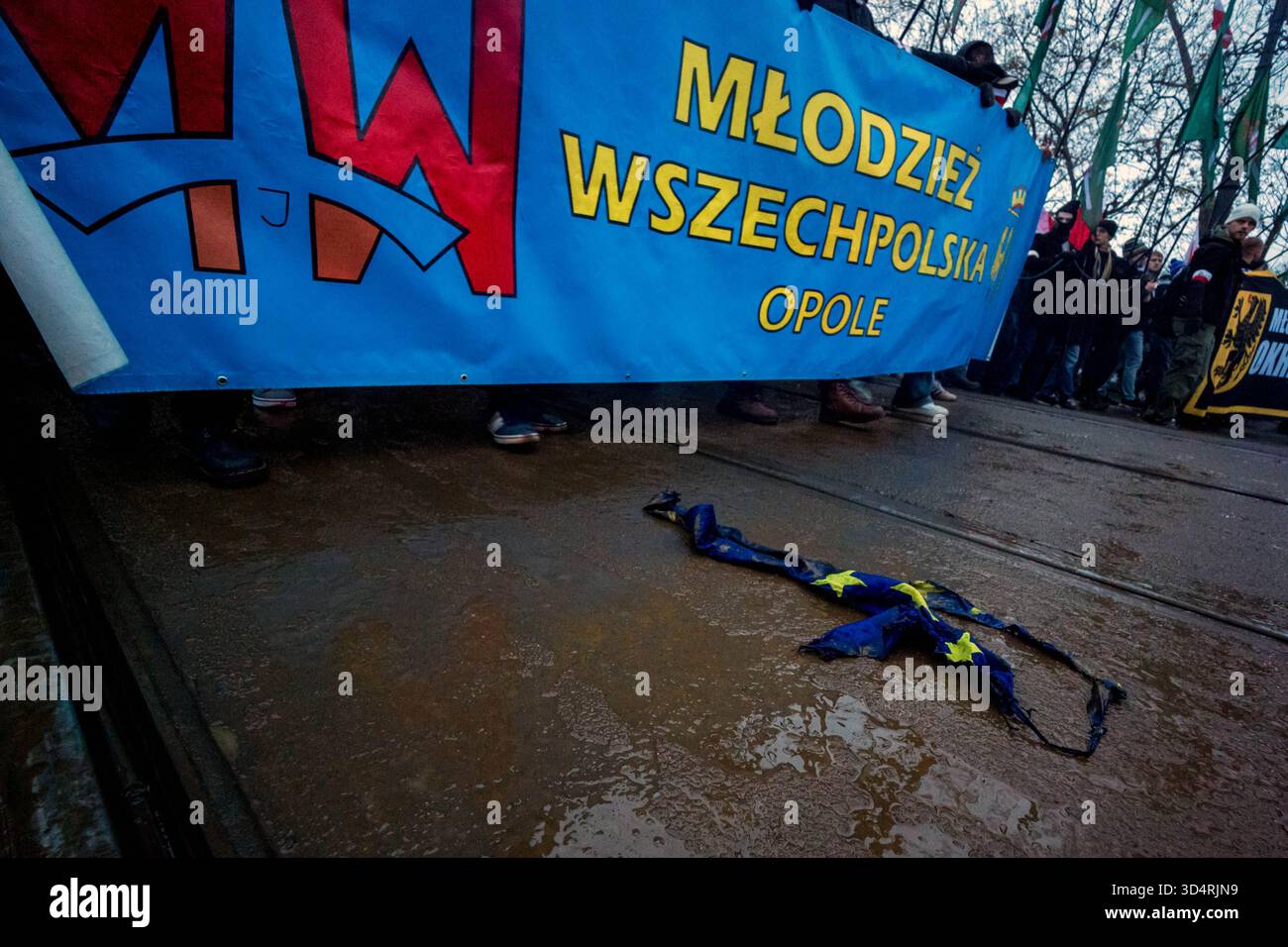 I resti di una bandiera bruciata dell'Unione europea vengono lasciati a terra durante la manifestazione. Nel pomeriggio dell'11 novembre, cittadini polacchi provenienti da tutto il paese hanno marciato per le strade di Varsavia per celebrare il giorno dell'indipendenza. Si stima che l'evento raccolga 100 mila partecipanti, con polacchi patriottici che si riuniscono per festeggiare. Molte famiglie portano i loro figli. La marcia ha sfumature religiose con molto simbolismo religioso visto nelle bandiere e nelle bandiere. Anche molte organizzazioni di estrema destra e fasciste hanno marciato. Quest'anno, il deputato polacco al Parlamento europeo Dominik Ta Foto Stock