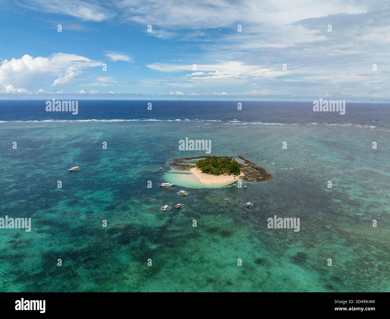 Vista dall'alto dell'isola sabbiosa con palme circondate da acque turchesi e barche nelle vicinanze. Isola di Guyam. Siargao, Filippine. Foto Stock