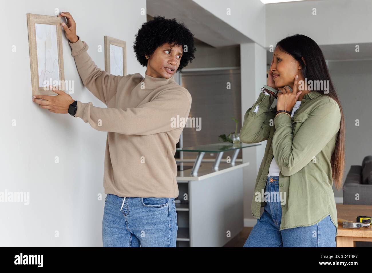 Appendere diverse coppie posizionando il telaio in legno contro le pareti interne, con metro a nastro e impianto Foto Stock