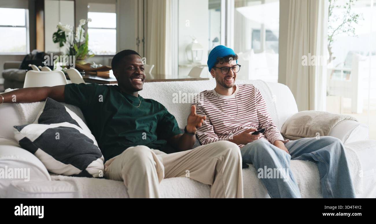 Amici, ridendo e guardando la tv sul divano con film divertenti, si uniscono e si ritrovano nel fine settimana. Persone felici, relax o servizio di streaming per commedie Foto Stock