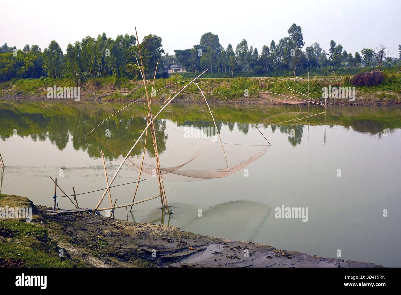 Reti da pesca tradizionali sopra un tranquillo fiume in un paesaggio lussureggiante Foto Stock