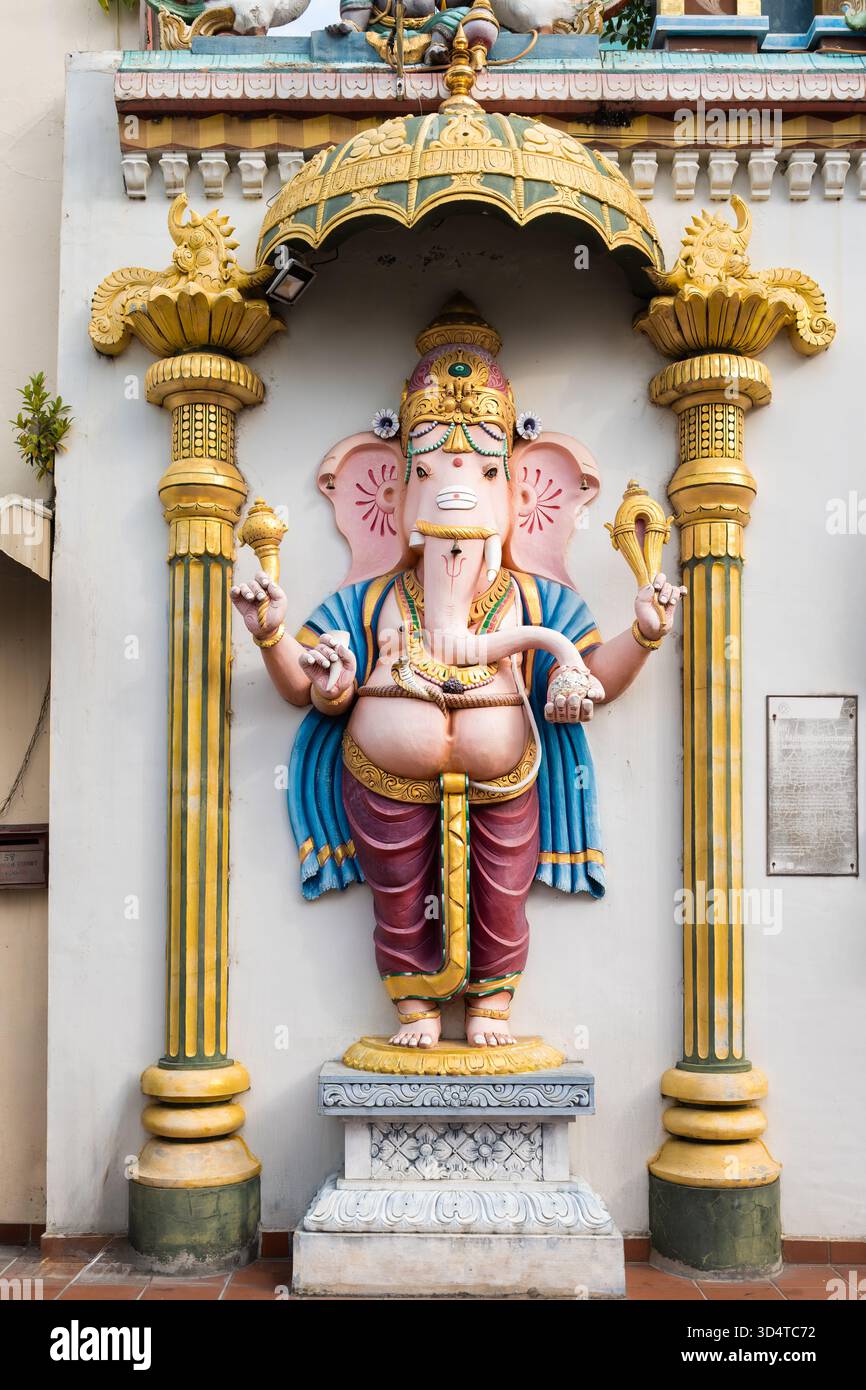 Una vibrante statua Ganesha si erge in modo prominente sulla strada, decorata con elementi decorativi sotto un baldacchino, che mostra la cultura e l'arte locale. Foto Stock