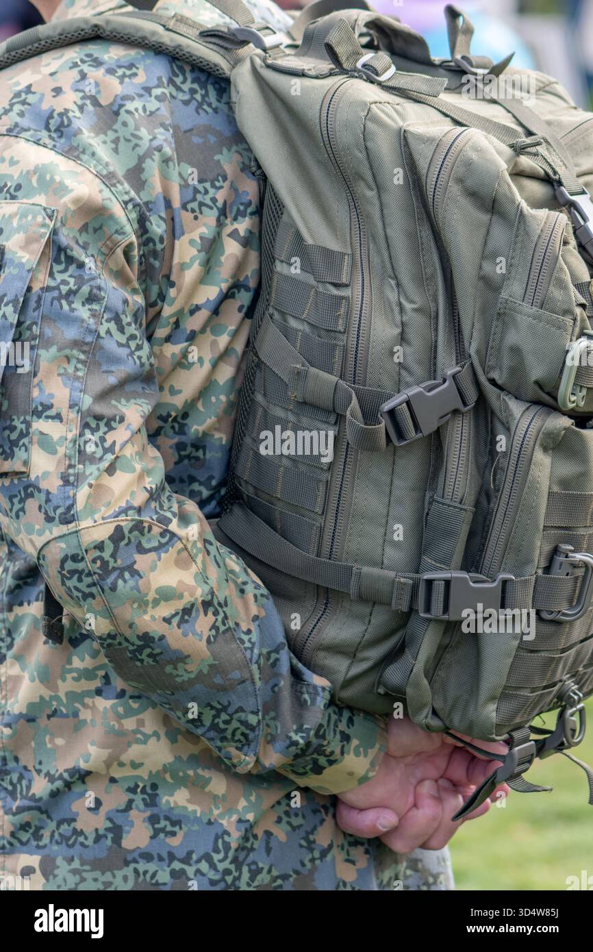 Un grande zaino dell'esercito è attaccato alla schiena di un soldato con un'uniforme mimetica Foto Stock