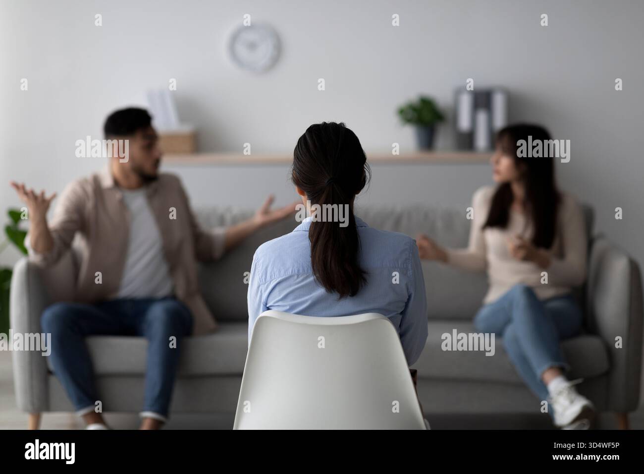 Sessione di terapia coniugale con psicologo e coppia araba che risolve i conflitti in ufficio Foto Stock