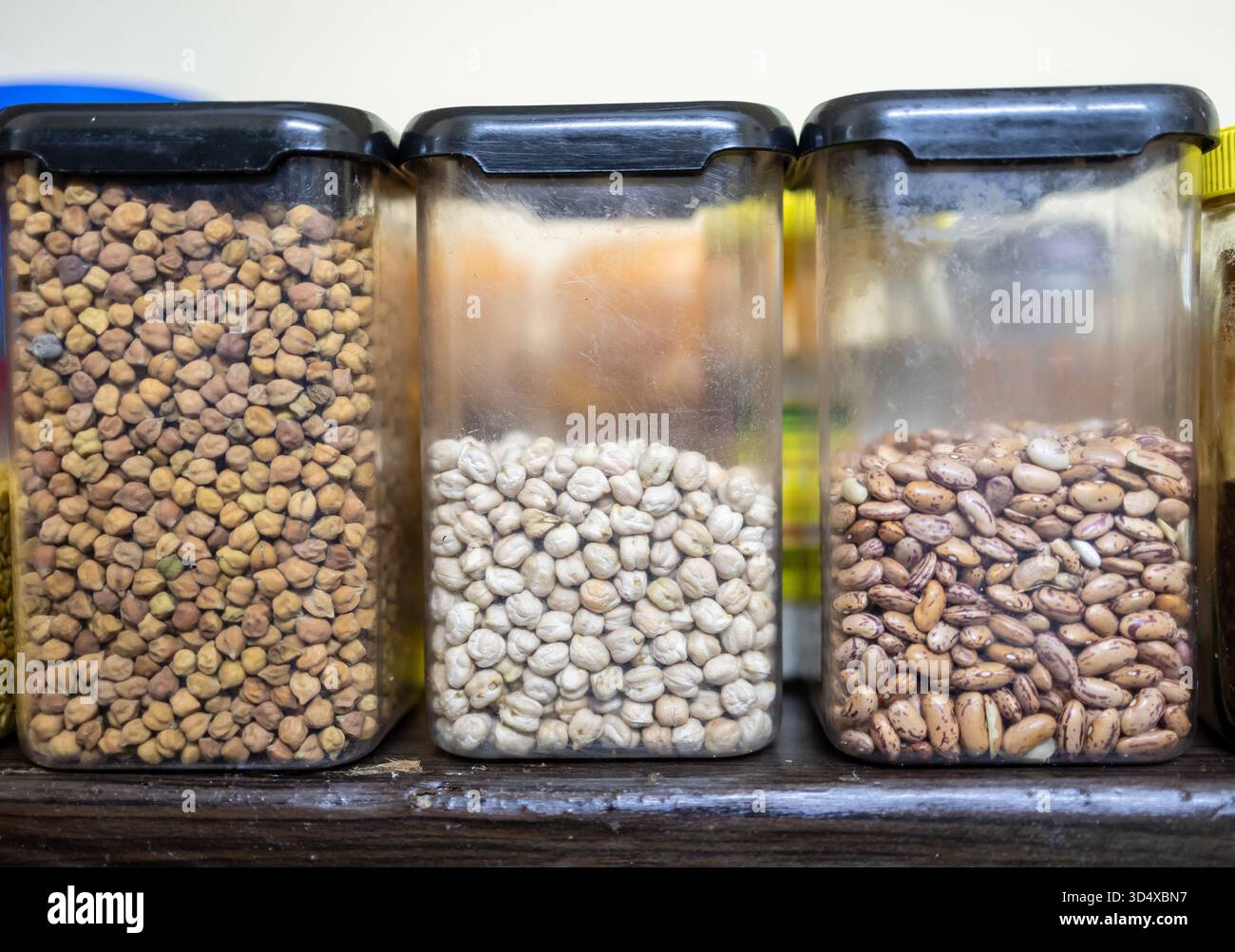 scaffale da cucina che espone fagioli secchi e lenticchie assortiti in vasetti Foto Stock