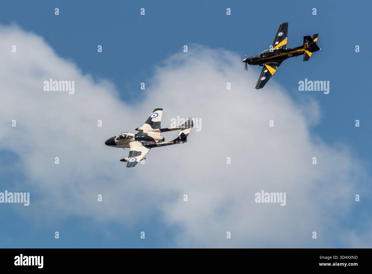 De Havilland Vampire nel deserto mimetico e RAF Short Tucano T1 in formazione di livrea nera/gialla contro il cielo blu. Niente persone, solo editoriale. Foto Stock