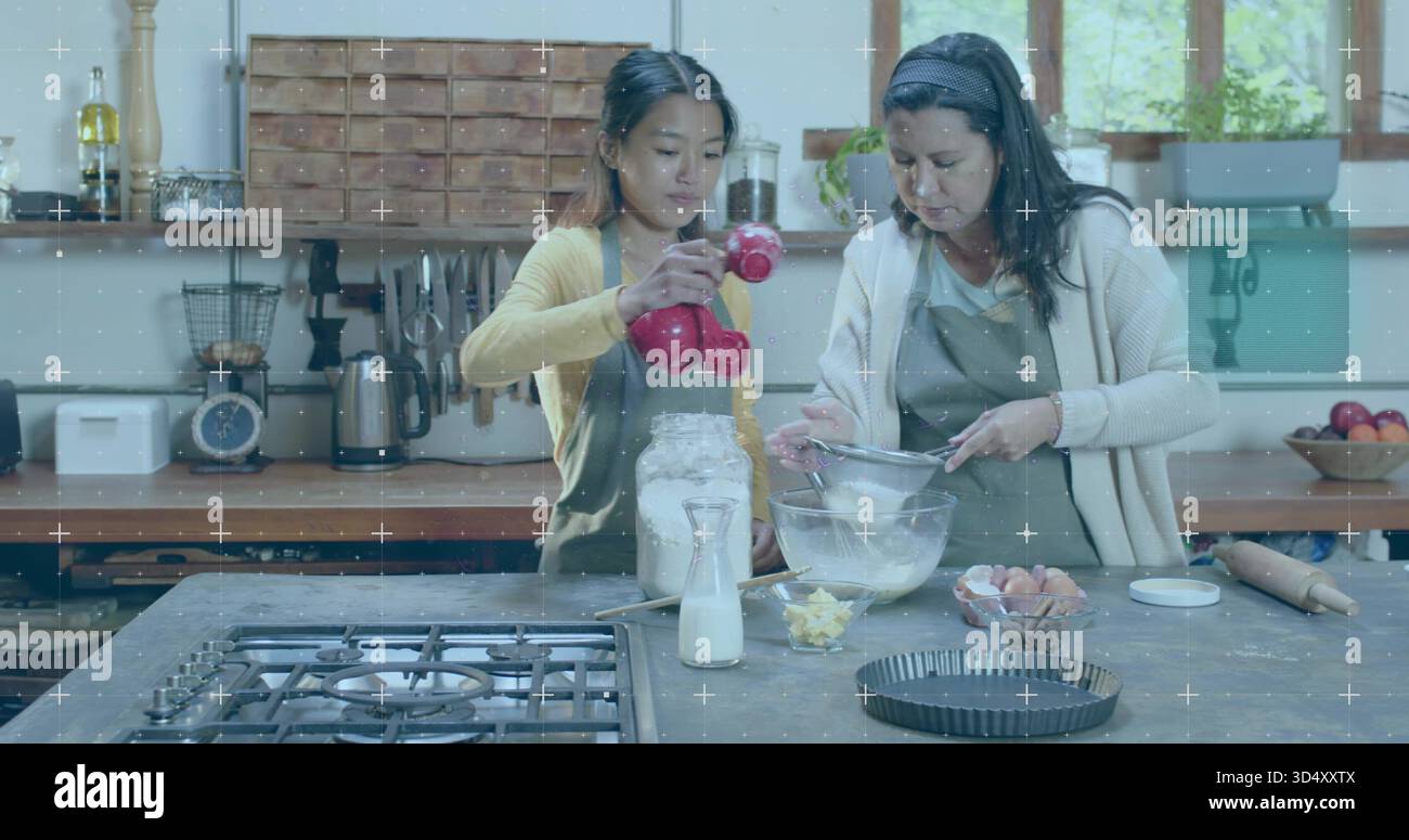 Versare e setacciare due donne in grembiuli per preparare la cottura in cucina, tazze rosse e setaccio Foto Stock