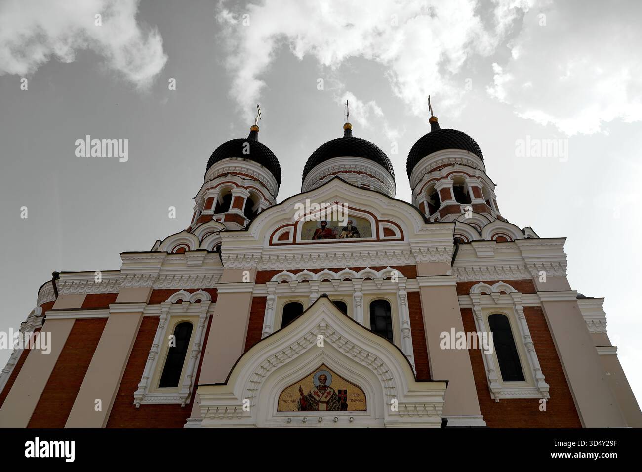 Tre cupole e livelli di facciata della cattedrale di Alexander Nevsky, chiesa ortodossa russa, contro la luce delle nuvole luminose a Tallinn, Estonia, da un'angolazione bassa. Foto Stock