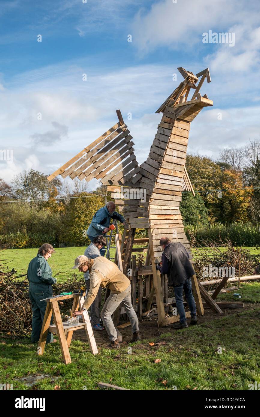 Costruire un falò a forma di gigante drago gallese per le celebrazioni della notte dei falò del 2017 nella città di confine gallese di Presteigne, Powys. L'evento è noto per i suoi elaborati falò costruiti da volontari locali ed è organizzato dal gruppo artistico locale Sheep Music. Foto Stock