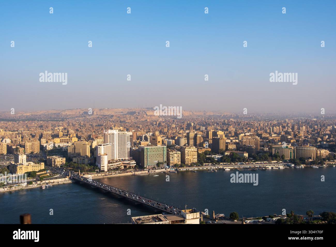 Vista di un vasto paesaggio urbano con il fiume Nilo che scorre, ponti che collegano vivaci quartieri sotto un cielo limpido, Zamalek, il Governatorato del Cairo, egitto Foto Stock