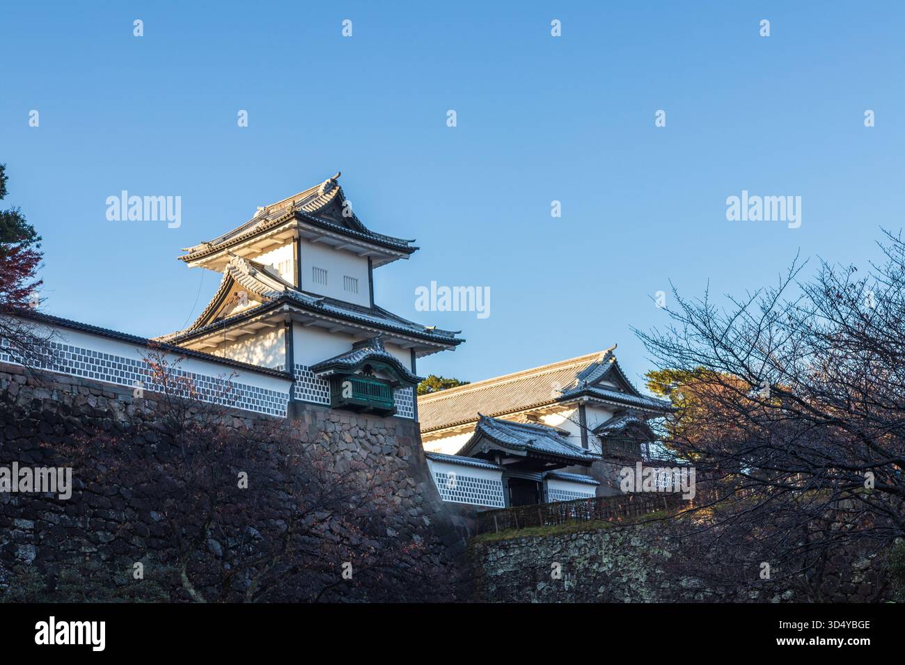 La vista di un antico castello giapponese con pareti bianche e tetti piastrellati si erge orgogliosamente contro un cielo azzurro limpido, una testimonianza della storia, Kanazawa, Ishikaw Foto Stock