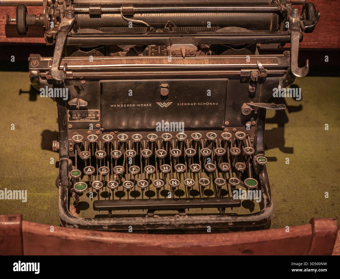 Primo piano ad angolo alto di una tastiera nera vintage Wanderer-Werke su una scrivania in feltro verde. Foto Stock