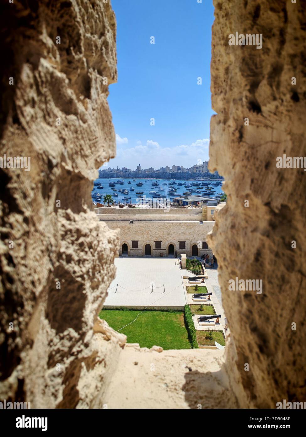 Vista del porto di Alessandria attraverso le antiche mura della Cittadella di Qaitbay, Egitto Foto Stock