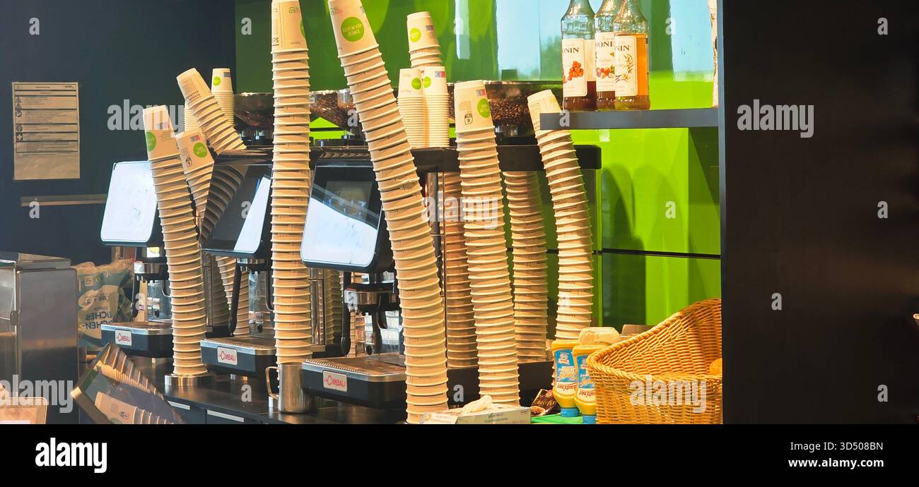Berlino, Germania - 25 settembre 2025: Gli interni della caffetteria presentano tazze impilate e macchine per caffè espresso sul bancone. - Immagine stock catturata con smartphone