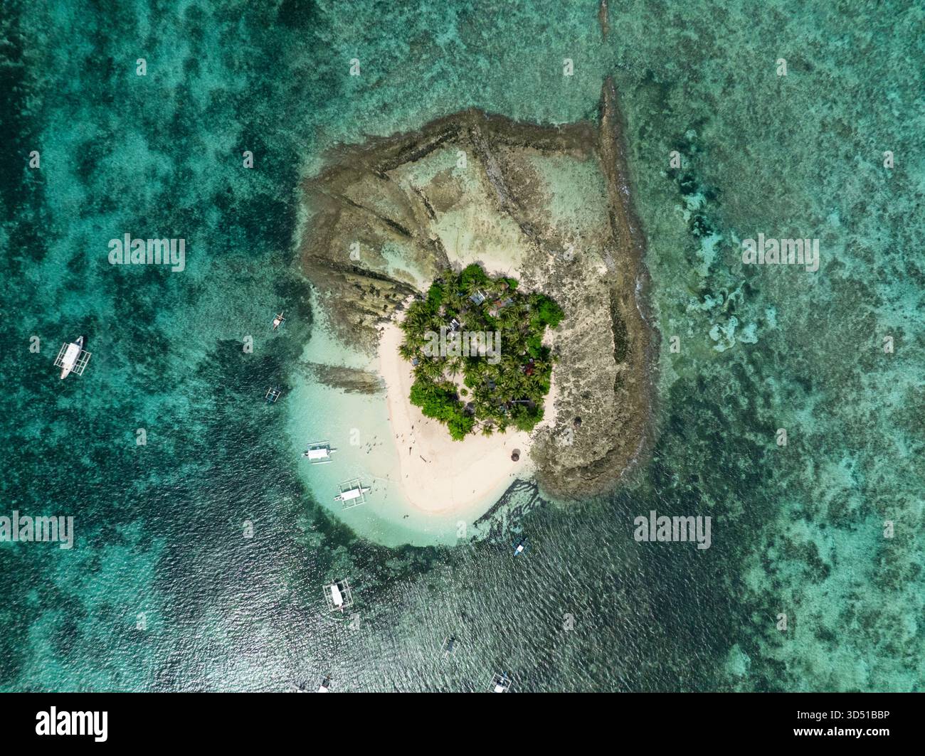 Piccola isola tropicale con palme spiaggia sabbiosa e barche in acqua turchese vicino alla barriera corallina. Isola di Guyam. Siargao, Filippine. Foto Stock