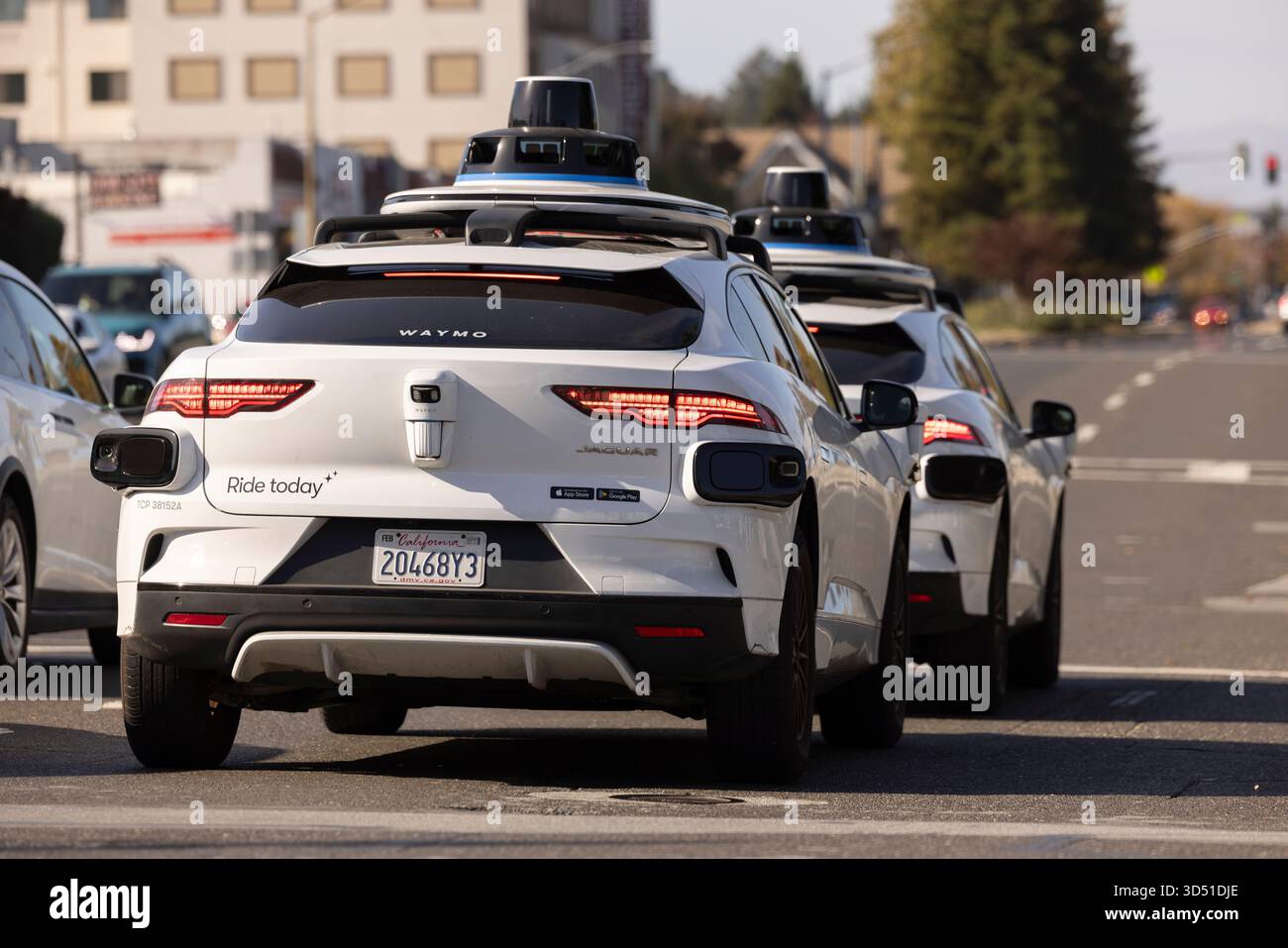 Belmont, California, USA - 30 ottobre 2025: Due macchine robotaxi Waymo a guida autonoma si fermano al semaforo. Foto Stock