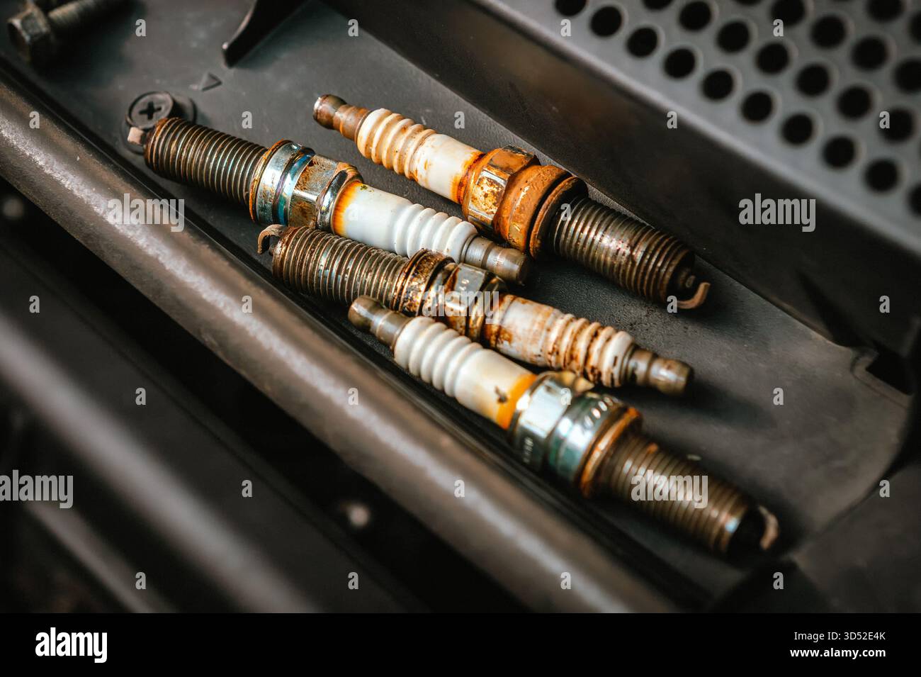 Candele automatiche usurate che indicano la manutenzione del veicolo e la riparazione del motore Foto Stock