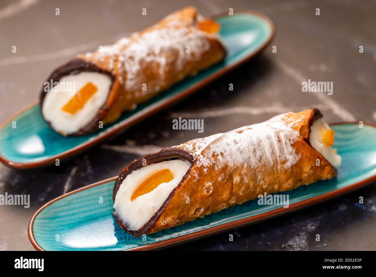 Cannoli ripieni di ricotta dolce spolverati con zucchero a velo e scorza d'arancia candita Foto Stock