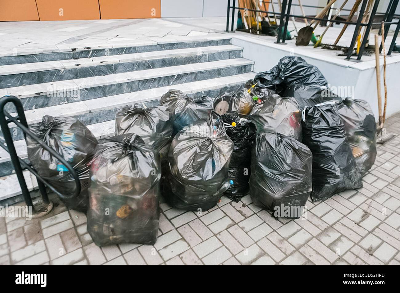 Sacchi di spazzatura sul marciapiede, il lavoro di un gianitore. Foto Stock