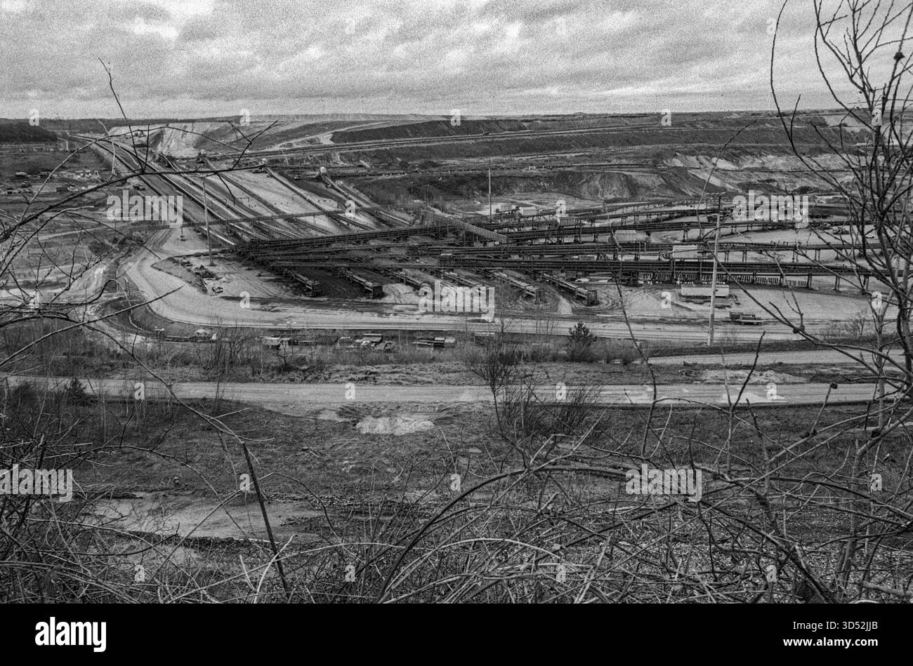 Garzweiler, Tagebau. La miniera di carbone marrone a cielo aperto di Garzweiler Tagebau sta diventando sempre più grande entro la settimana, estraendo combustibili fossili come la lignite e il carbone marrone che alimentano la vicina centrale elettrica di Garzweiler Kraftwerk e produce enormi quantità di gas serra come carbonio e CO2, contribuendo così al riscaldamento globale e ai cambiamenti climatici. Intere Forrests sono state demolite, e aolso agri villaggi culturali di fine terra. Nordrhine-Westfalia, Germania. Girato su Analog Black & White Film, 2024. Garzweiler Garzweiler Tagebau Nordrhein-Westfalen Germania Copyright: XGuidoxKoppesxPhotox Foto Stock