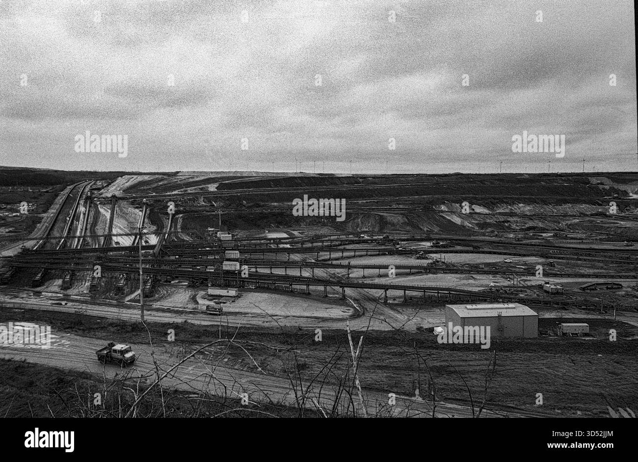 Garzweiler, Tagebau. La miniera di carbone marrone a cielo aperto di Garzweiler Tagebau sta diventando sempre più grande entro la settimana, estraendo combustibili fossili come la lignite e il carbone marrone che alimentano la vicina centrale elettrica di Garzweiler Kraftwerk e produce enormi quantità di gas serra come carbonio e CO2, contribuendo così al riscaldamento globale e ai cambiamenti climatici. Nordrhine-Westfalia, Germania. Girato su Analog Black & White Film, 2024. Garzweiler Garzweiler Tagebau Nordrhein-Westfalen Germania Copyright: XGuidoxKoppesxPhotox Foto Stock