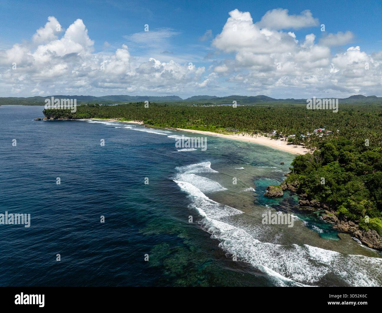 Il litorale con spiaggia sabbiosa, bordi rocciosi e foresta tropicale si incontrano con le onde dell'oceano. Siargao, Filippine. Piscina di marea Magpupungko. Foto Stock