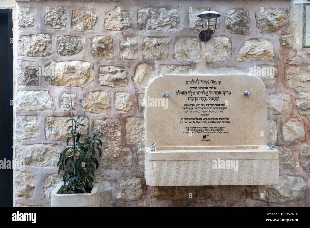 Gerusalemme, Israele, 6 luglio 2025 Memoriale di guerra situato in HaGal-ed Alley, quartiere ebraico. Fontana commemorativa in un grezzo muro di pietra, dedica Foto Stock