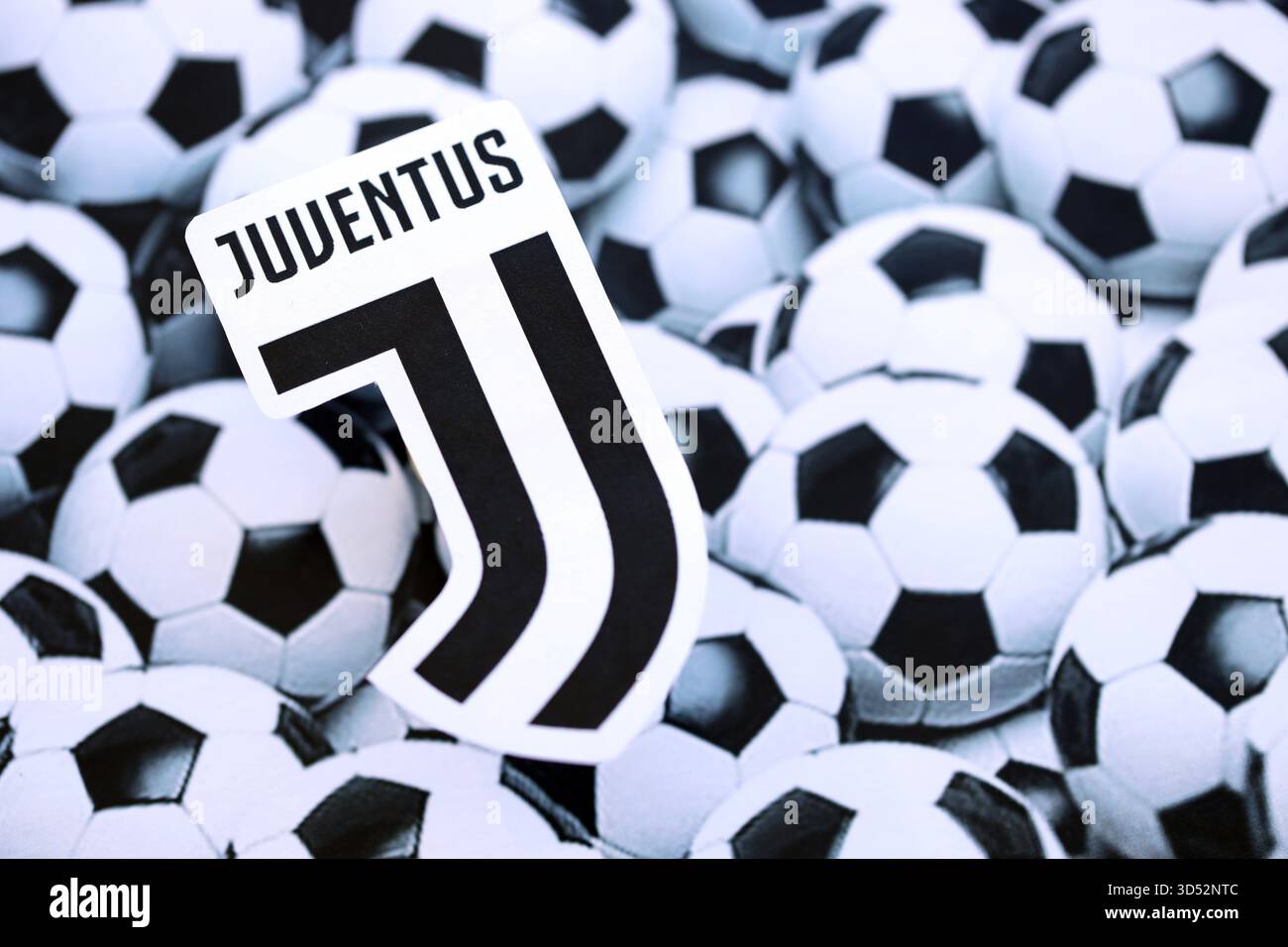 KIEV, UCRAINA - 23 FEBBRAIO 2025 il badge della squadra di calcio della Juventus FC si trova sullo sfondo delle palle da calcio Foto Stock