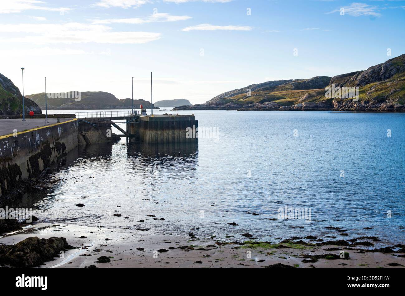 Vista serale dal litorale di Loch Clash, Kinlochbervie, Sutherland, con la bassa marea, con il vecchio porto di pescatori e la banchina sulla sinistra. Foto Stock