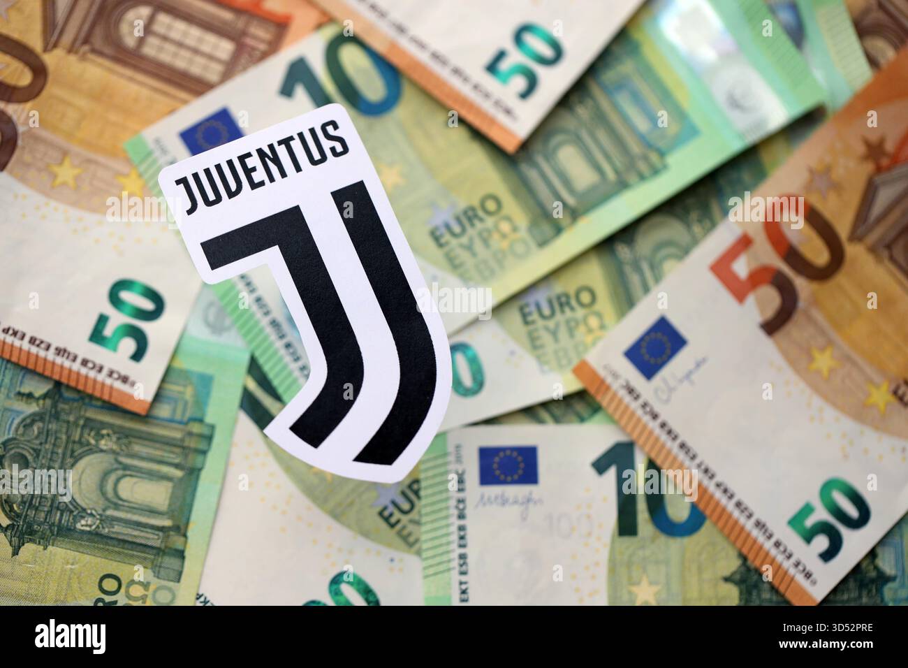 KIEV, UCRAINA - 23 FEBBRAIO 2025 il distintivo della squadra di calcio della Juventus FC si trova su una grossa somma di cento banconote in denaro Foto Stock