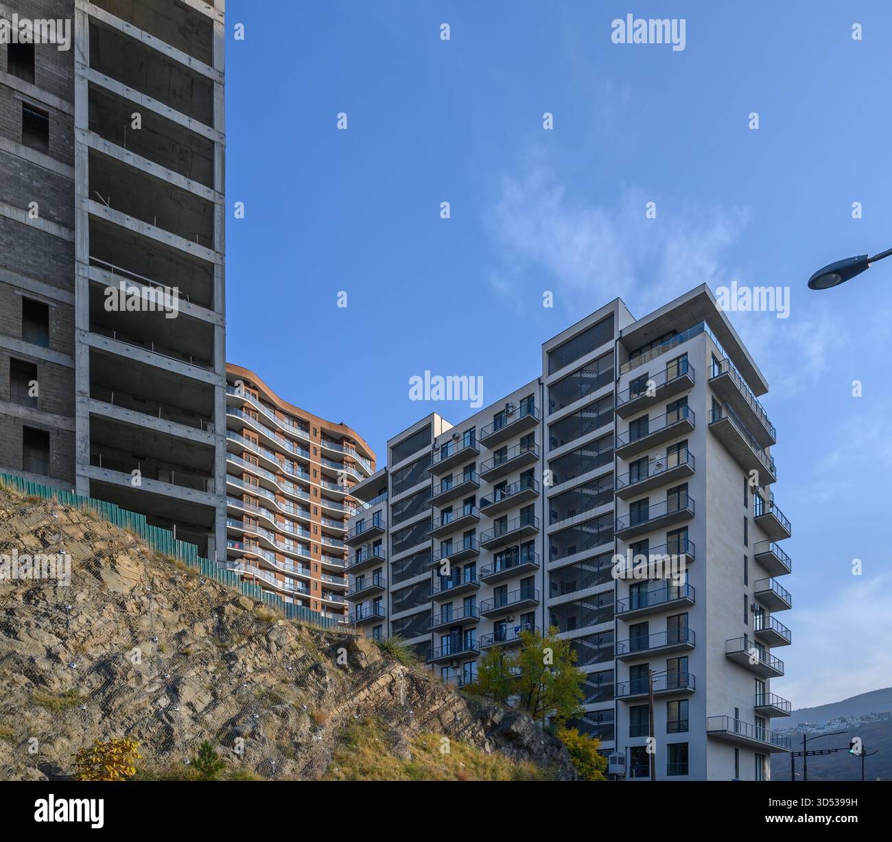 Una vista del dinamico paesaggio urbano di Tbilisi che mostra sia edifici in fase di costruzione che edifici residenziali completati, riflettendo il rapido sviluppo urbano della città Foto Stock