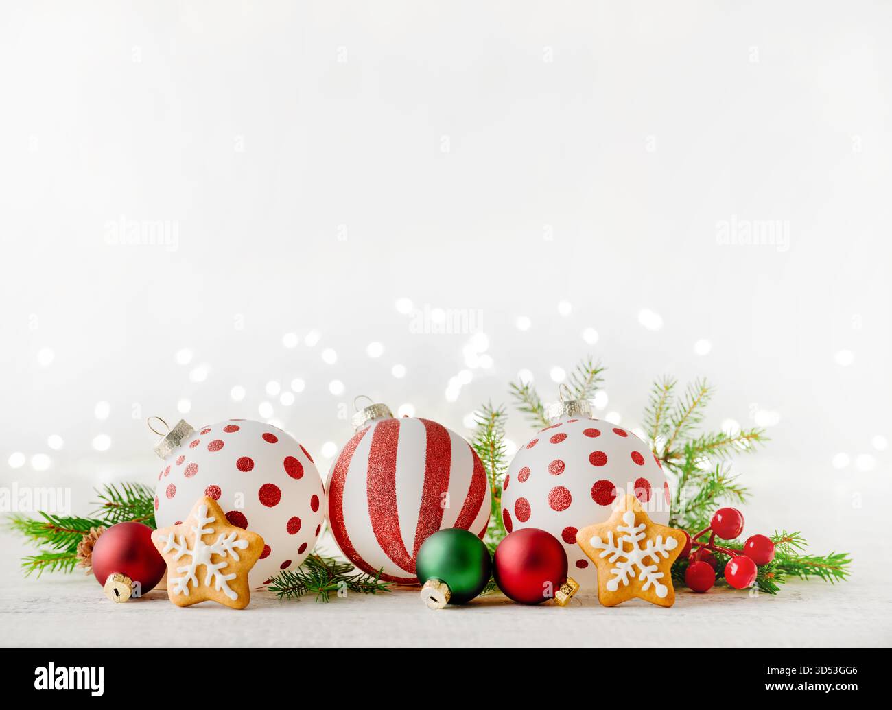 Biscotti stellati di pan di zenzero di Natale, decorazioni natalizie rami di alberi di Natale, regali e giocattoli su sfondo in legno con luce bokeh garland . Elemento di design del biglietto di Natale. Foto Stock
