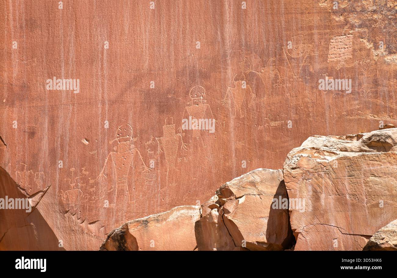 Antichi petroglifi scolpiti in una scogliera di pietra arenaria rossa nel Capitol Reef National Park. Le incisioni raffigurano figure umane e animali della cultura Fremont Foto Stock