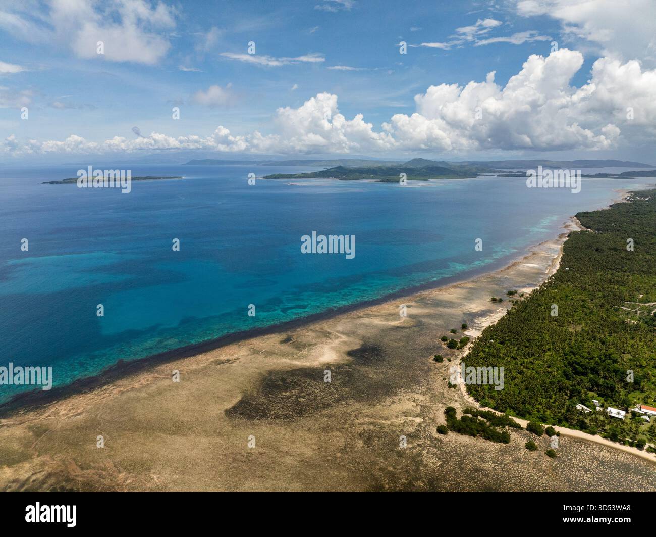 Vista aerea della costa con la barriera corallina e le acque cristalline sotto il cielo blu. Siargao, Filippine. Foto Stock