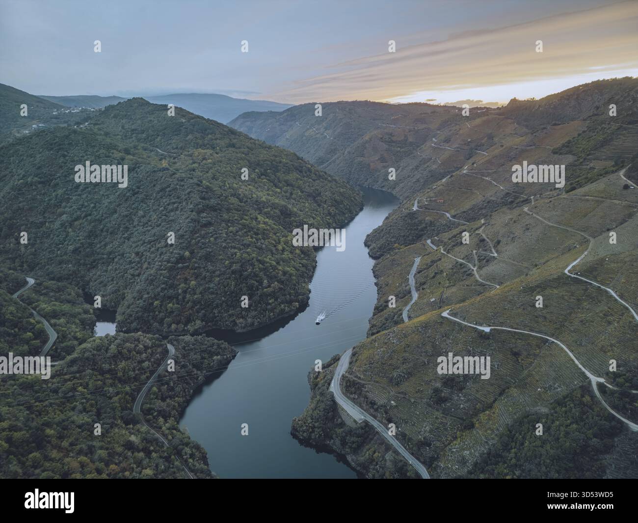 Vista aerea del fiume Sil che attraversa le colline verdeggianti, una serena via d'acqua che riflette la luce soffusa del cielo, delimitata da strade tortuose e densa prua Foto Stock
