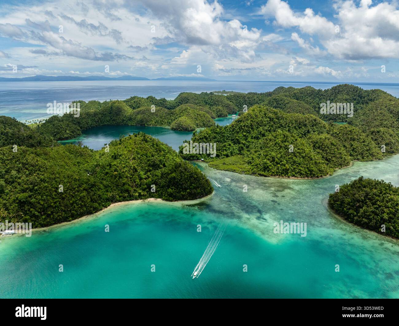 Baia tropicale turchese con barche che si muovono tra le verdi isole boschive. Siargao, Filippine. Laguna blu di Sugba. Foto Stock