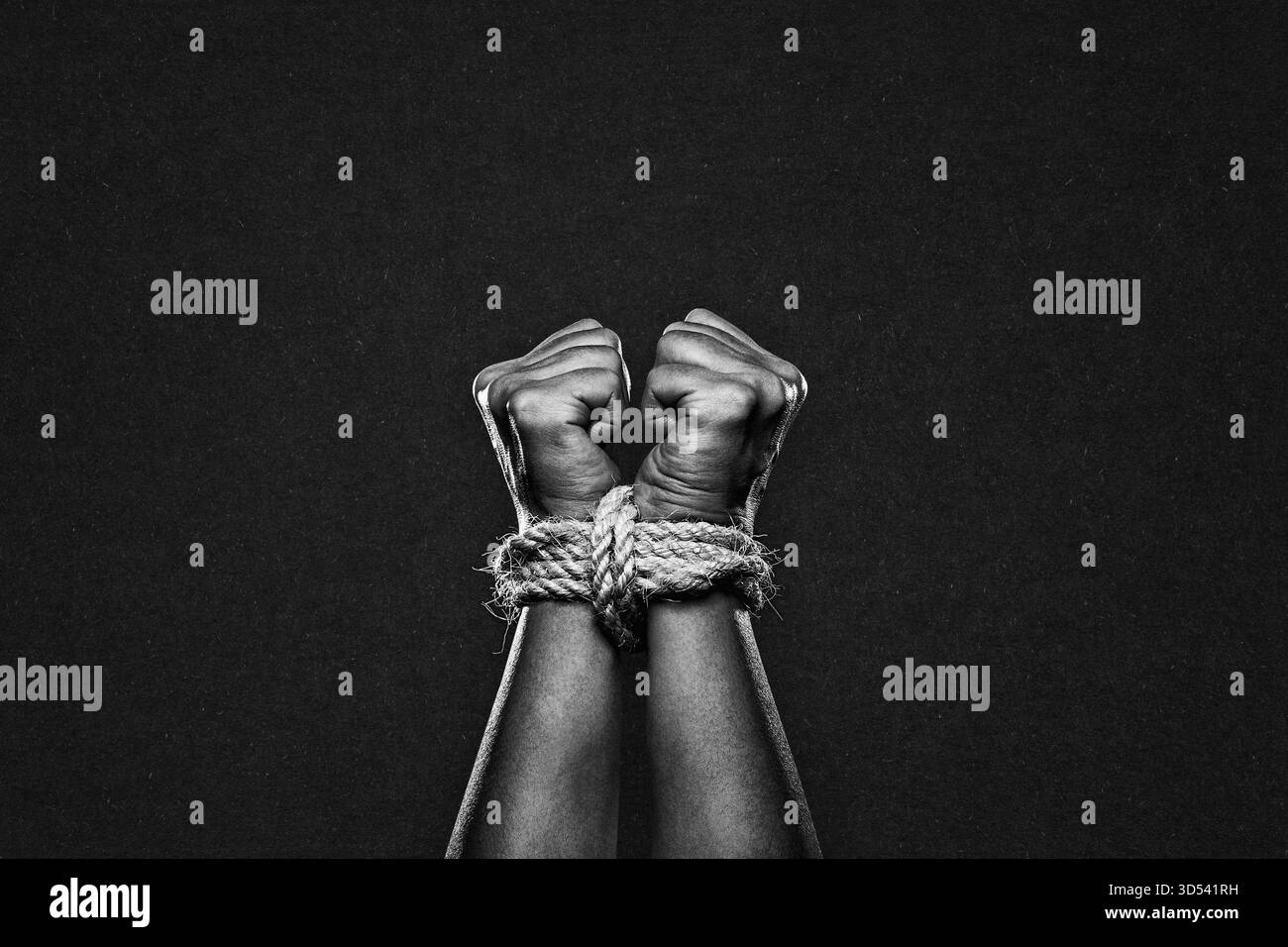 Mani legate con corda in bianco e nero su sfondo in carta testurizzata Foto Stock