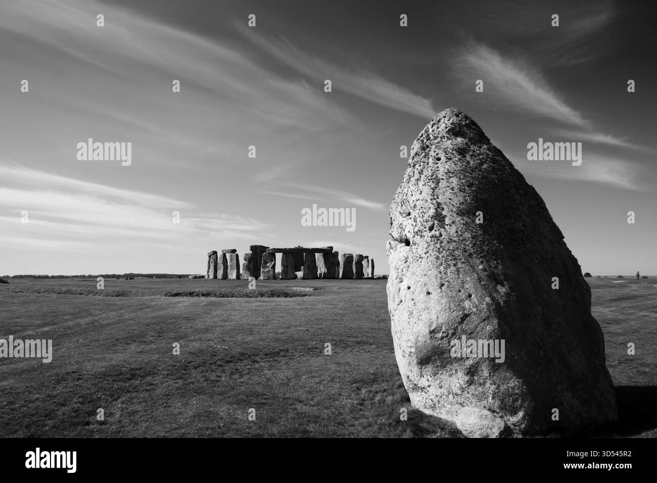 L'iconico gruppo di pietre di Stonehenge all'orizzonte è circondato da un "henge" esterno di pietre di cui questa è la più importante. Foto Stock