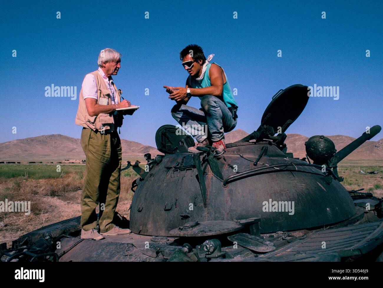 Sandy Gall e Tim Porter del "HALO Trust" in Afghanistan, 1992, su un carro armato disinnestato da una trappola esplosiva. Foto Stock