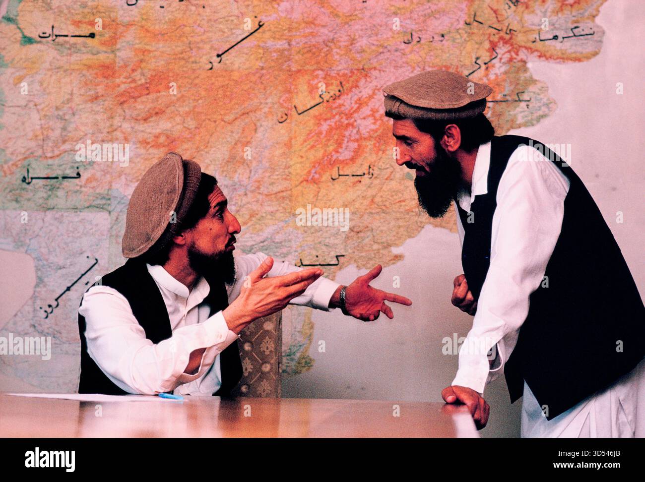 Ahmed Shah Masoud, leader mujahideen, in una discussione con un altro uomo nel suo ufficio a Kabul, Afghanistan, 1992. Foto Stock