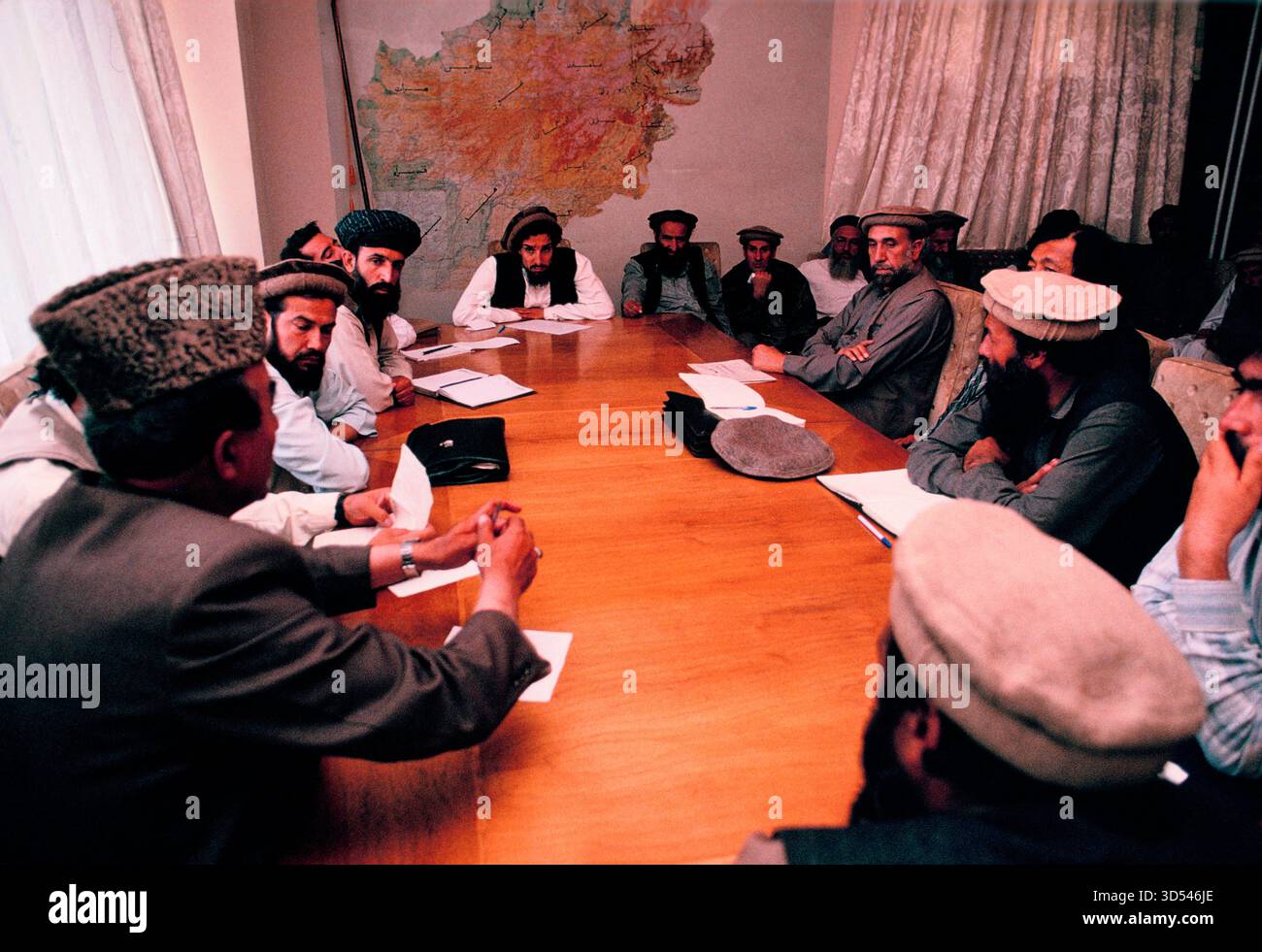 Ahmed Shah Masoud, leader mujahideen, in un incontro con altri nel suo ufficio a Kabul, Afghanistan, 1992. Foto Stock