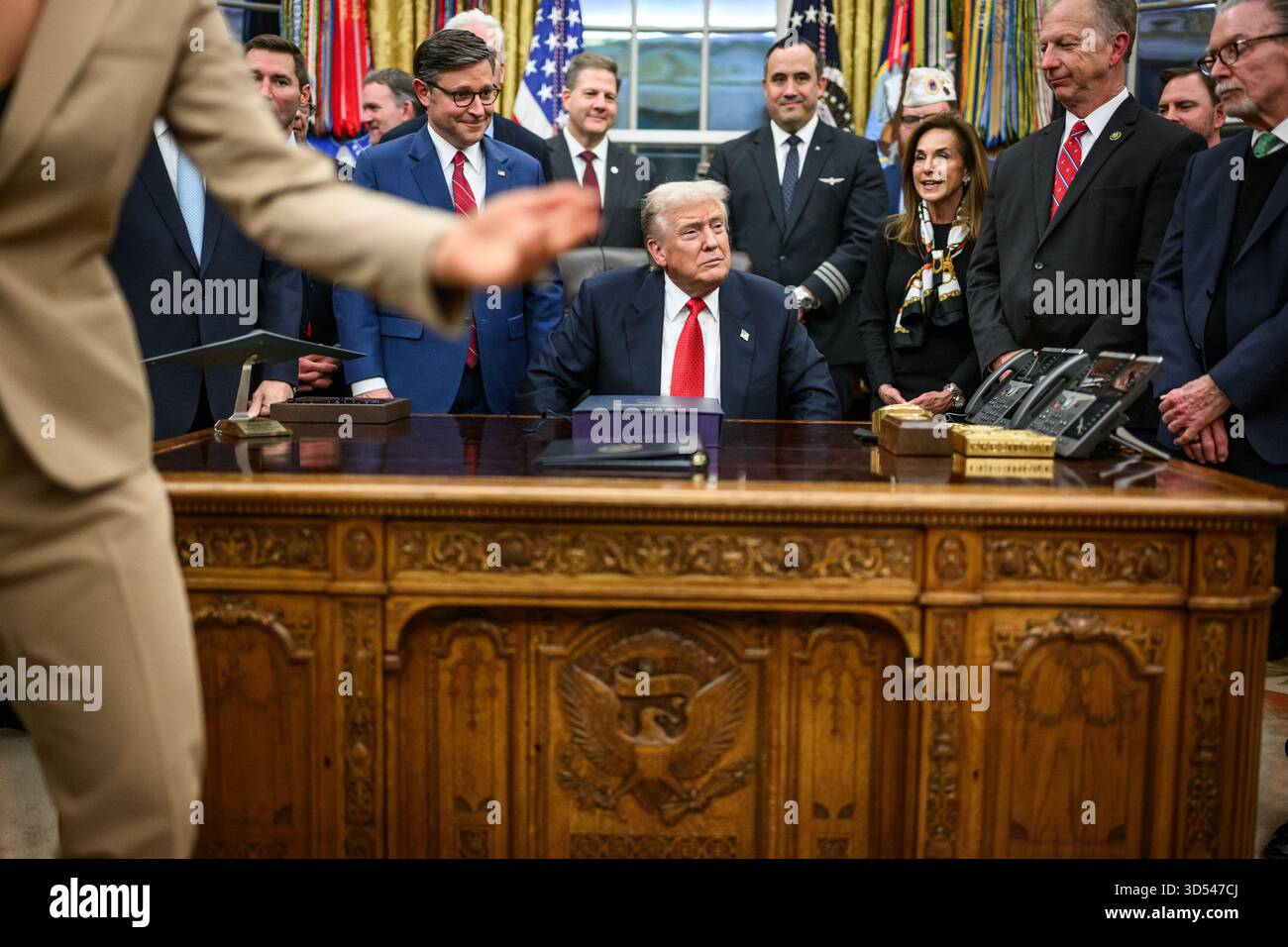 Il presidente Donald Trump mostra ai membri dei media il disegno di legge firmato dal Congresso che riapre il governo, mercoledì 12 novembre 2025, nell'Ufficio ovale. (Foto ufficiale della Casa Bianca di Daniel Torok) Foto Stock